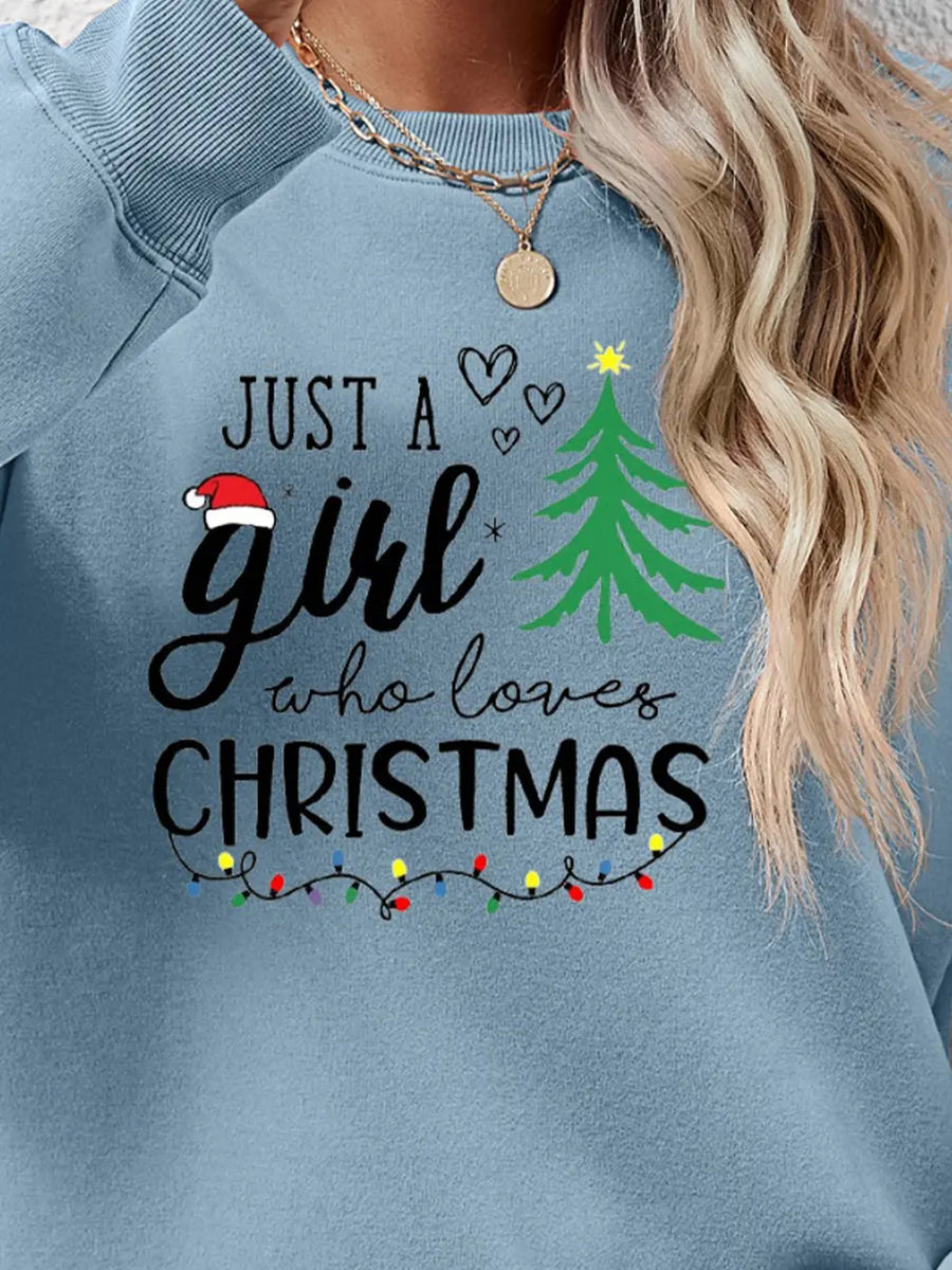 Misty Blue crewneck sweatshirt with "Just a girl who loves Christmas" graphic and string lights.