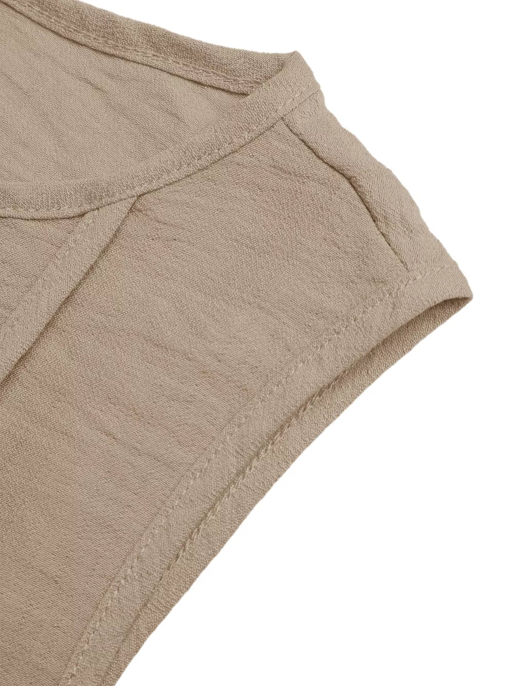 Textured beige maxi dress detail showing seam and fabric texture.