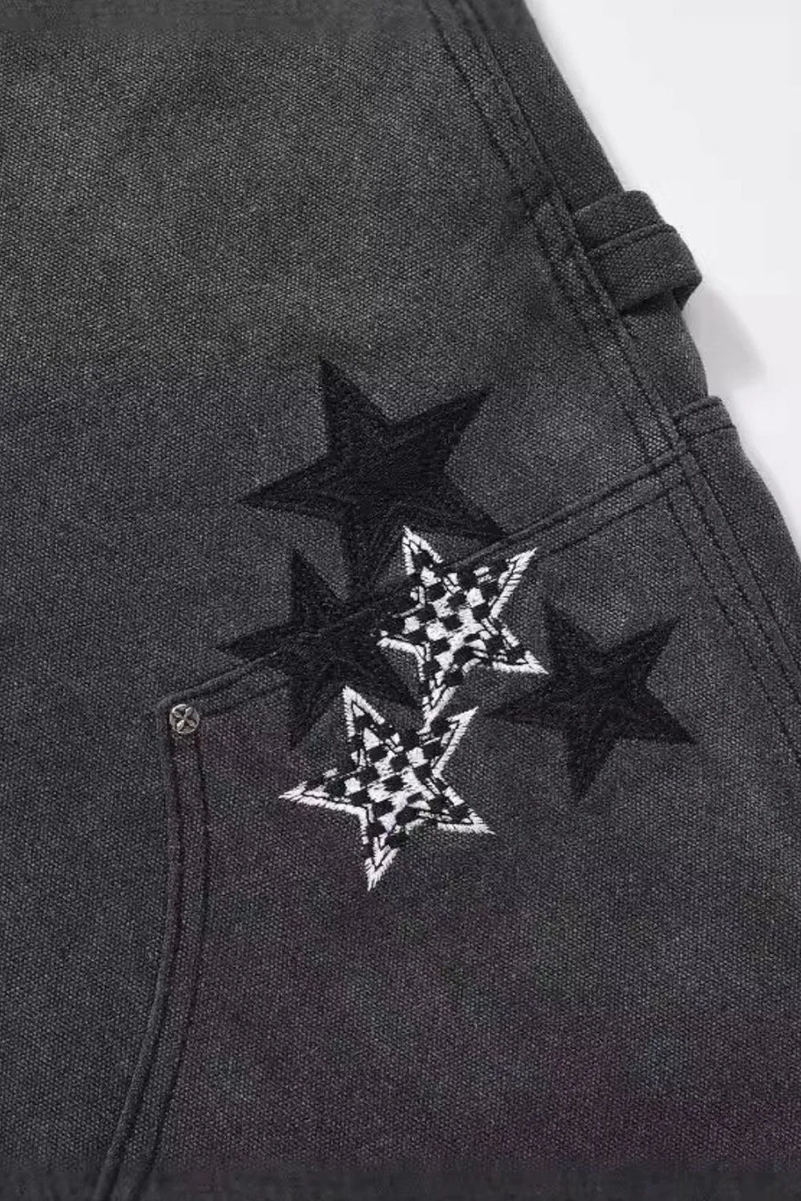 Dark carpenter jeans with embroidered stars, some with checkered pattern detail.
