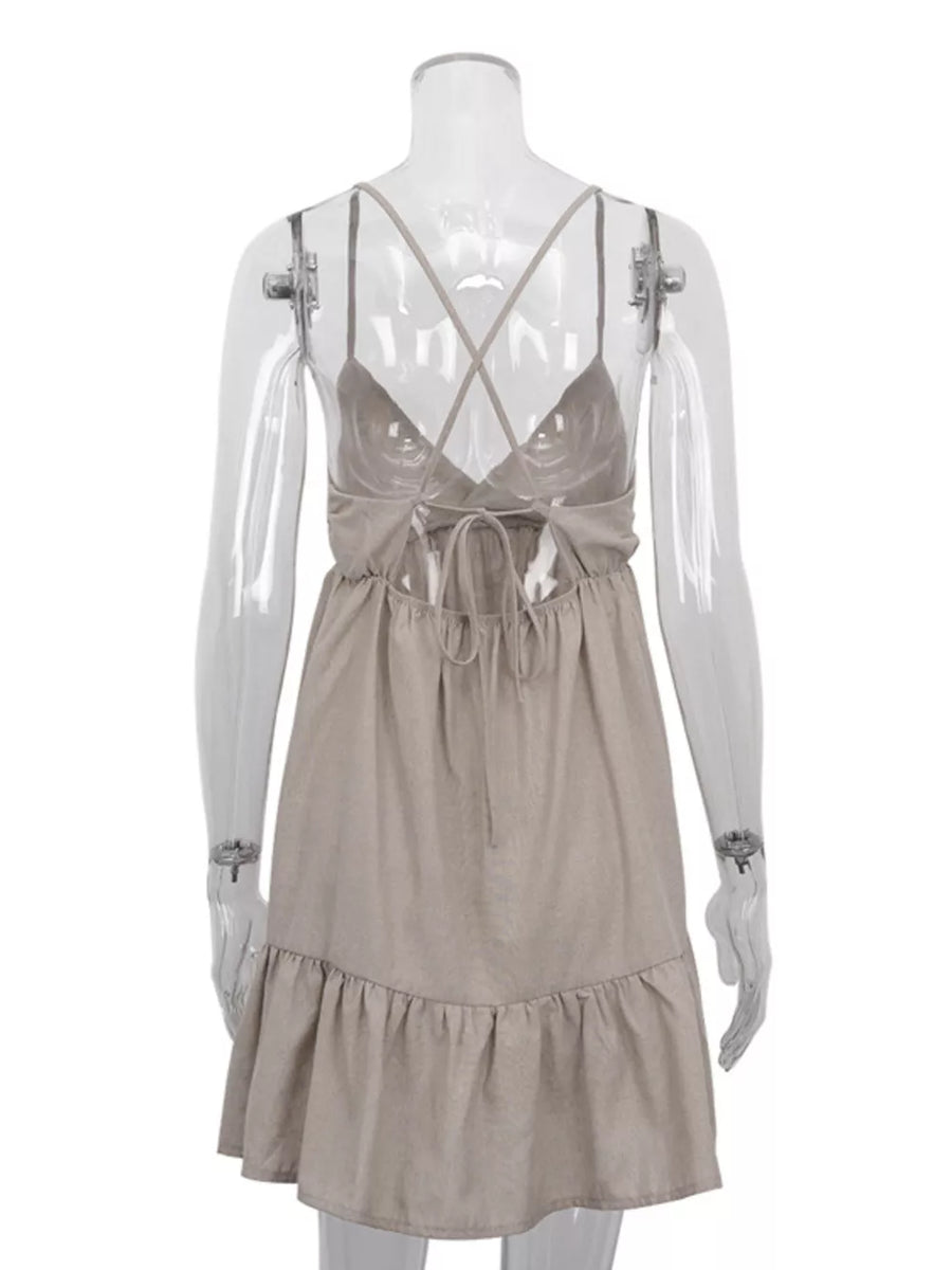 Tan linen blend mini dress with crisscross straps, tie back, and ruffled hem