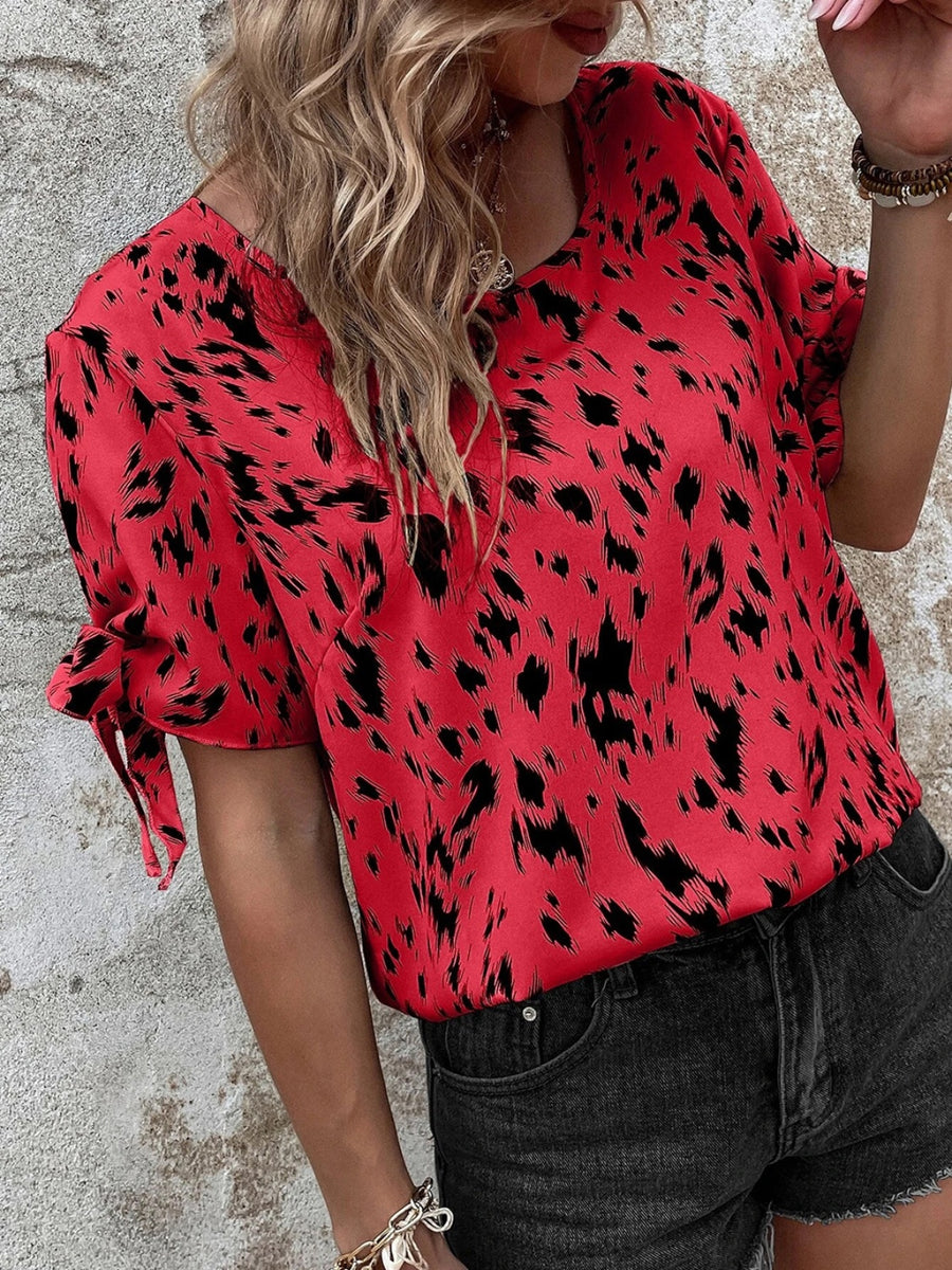 Scarlet Dalmatian print blouse with bow sleeves and a boatneck neckline.