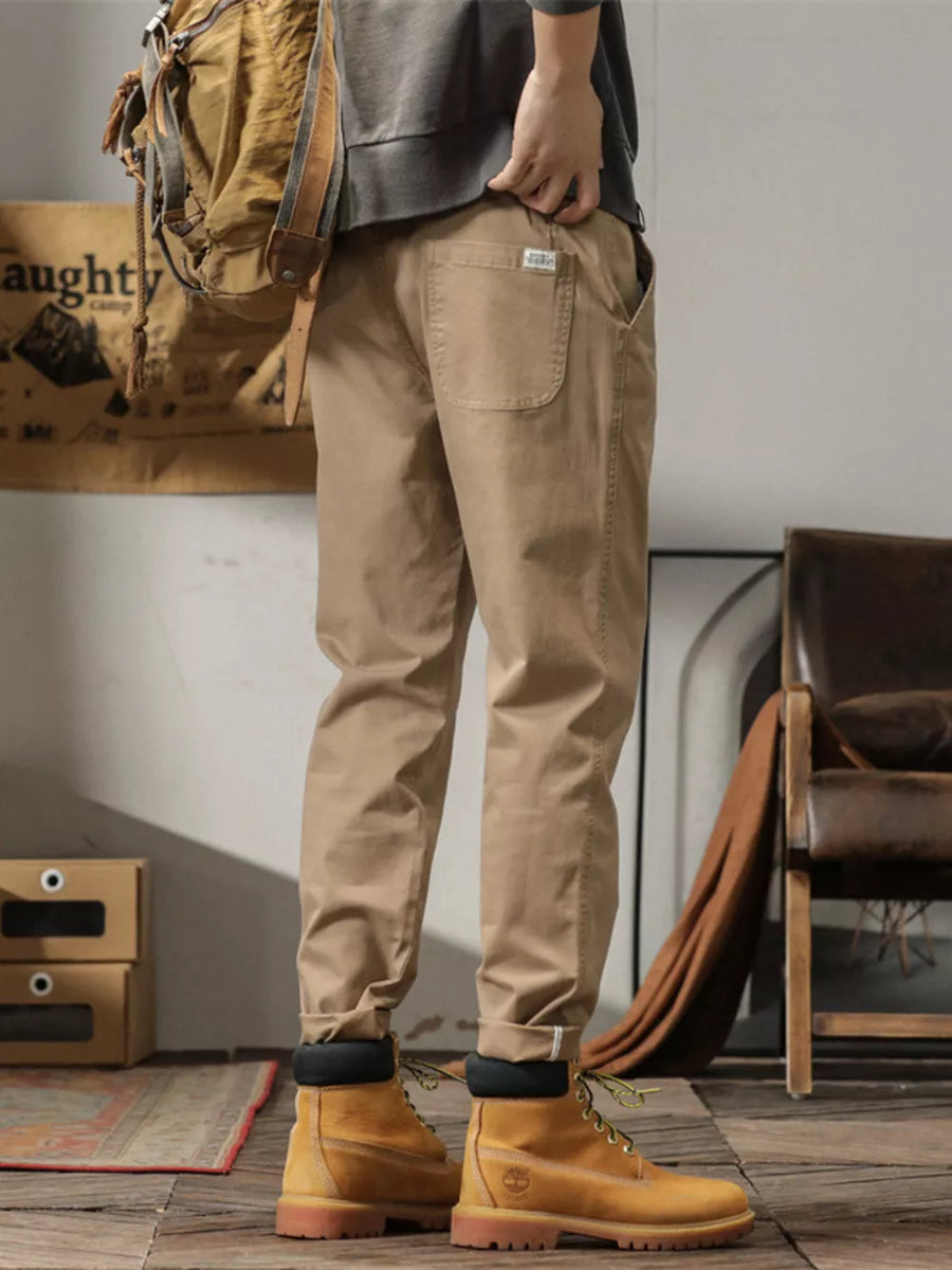 Men's khaki slim fit ankle pants with cuffed hem and back pocket detail.