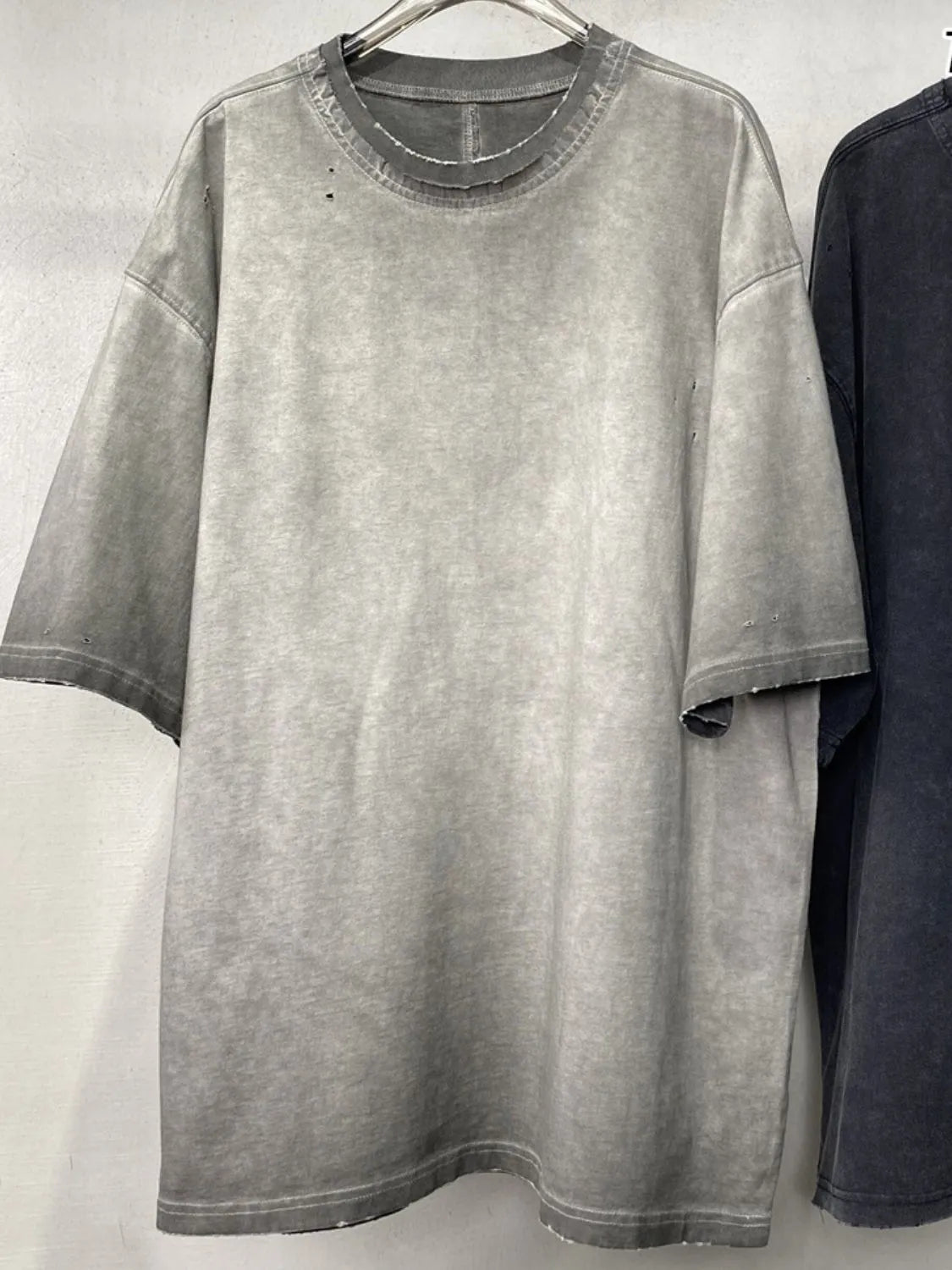 Gray oversized 100% cotton tee with washed effect and distressed details.