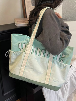 Green shoulder bag with bold white lettering and drawstring pockets