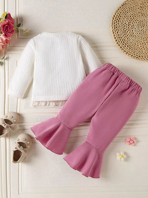 Baby girl's white textured top with lace trim and mauve flare pants.