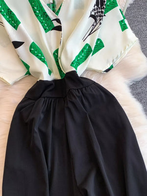 Abstract print white romper with green accents and black wide legs.