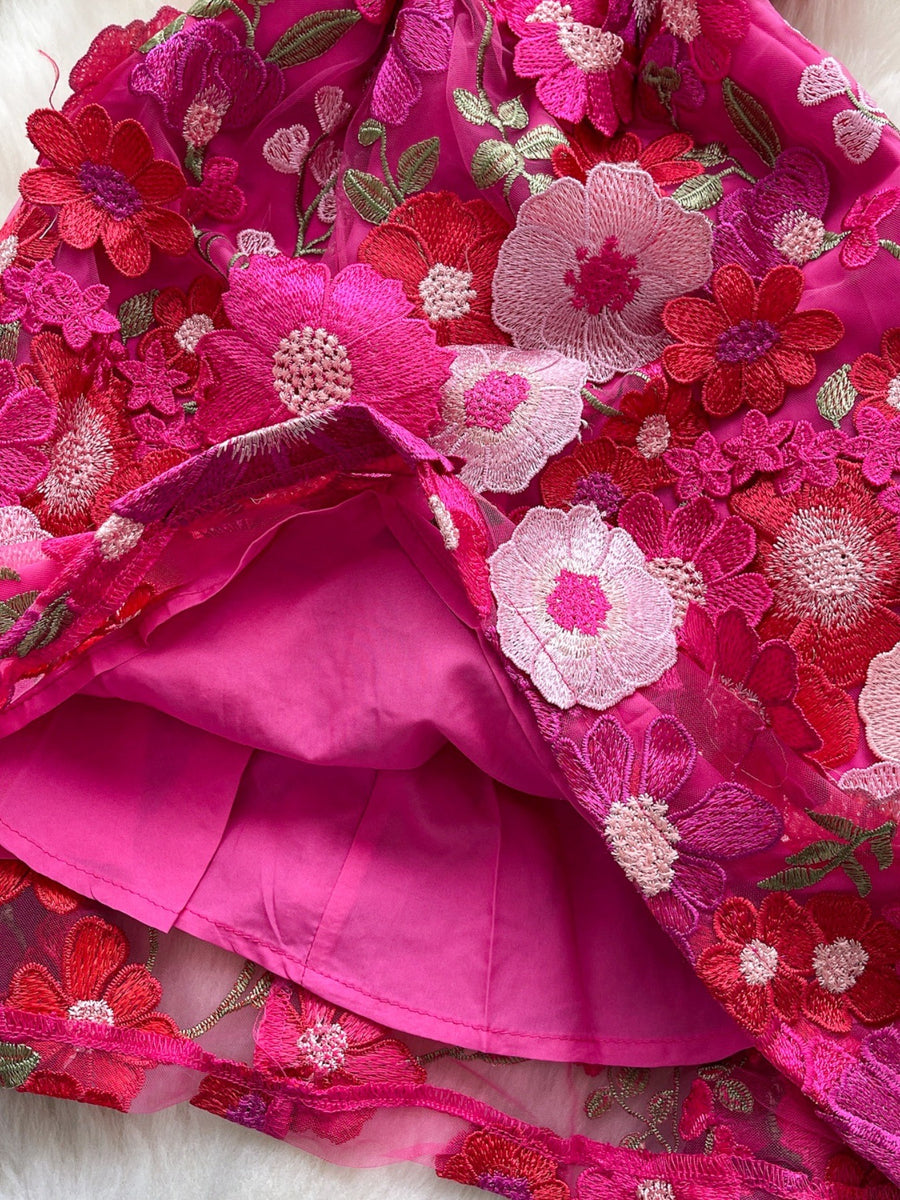 Embroidered floral mini dress in vibrant pink with layered mesh and applique flowers.
