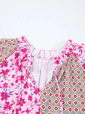 Boho floral print blouse in fuchsia pink with geometric print panels, ruffled neckline and tie detail.