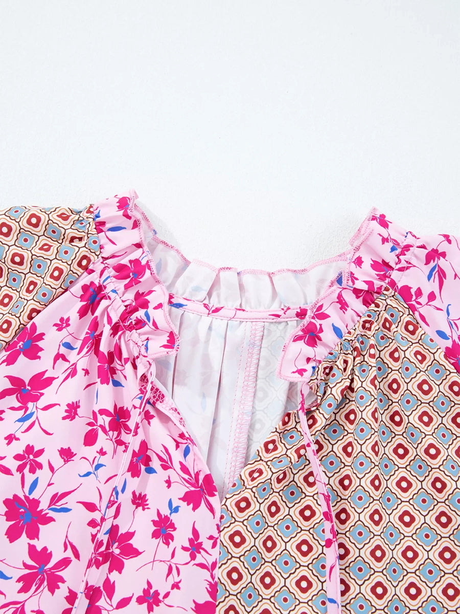 Boho floral print blouse in fuchsia pink with geometric print panels, ruffled neckline and tie detail.