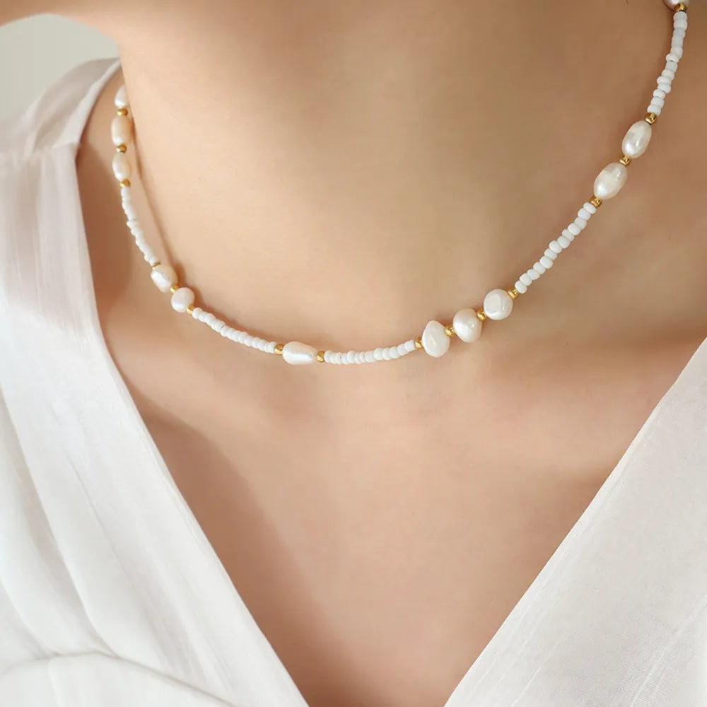 White pearl and seed bead strand necklace with gold accents
