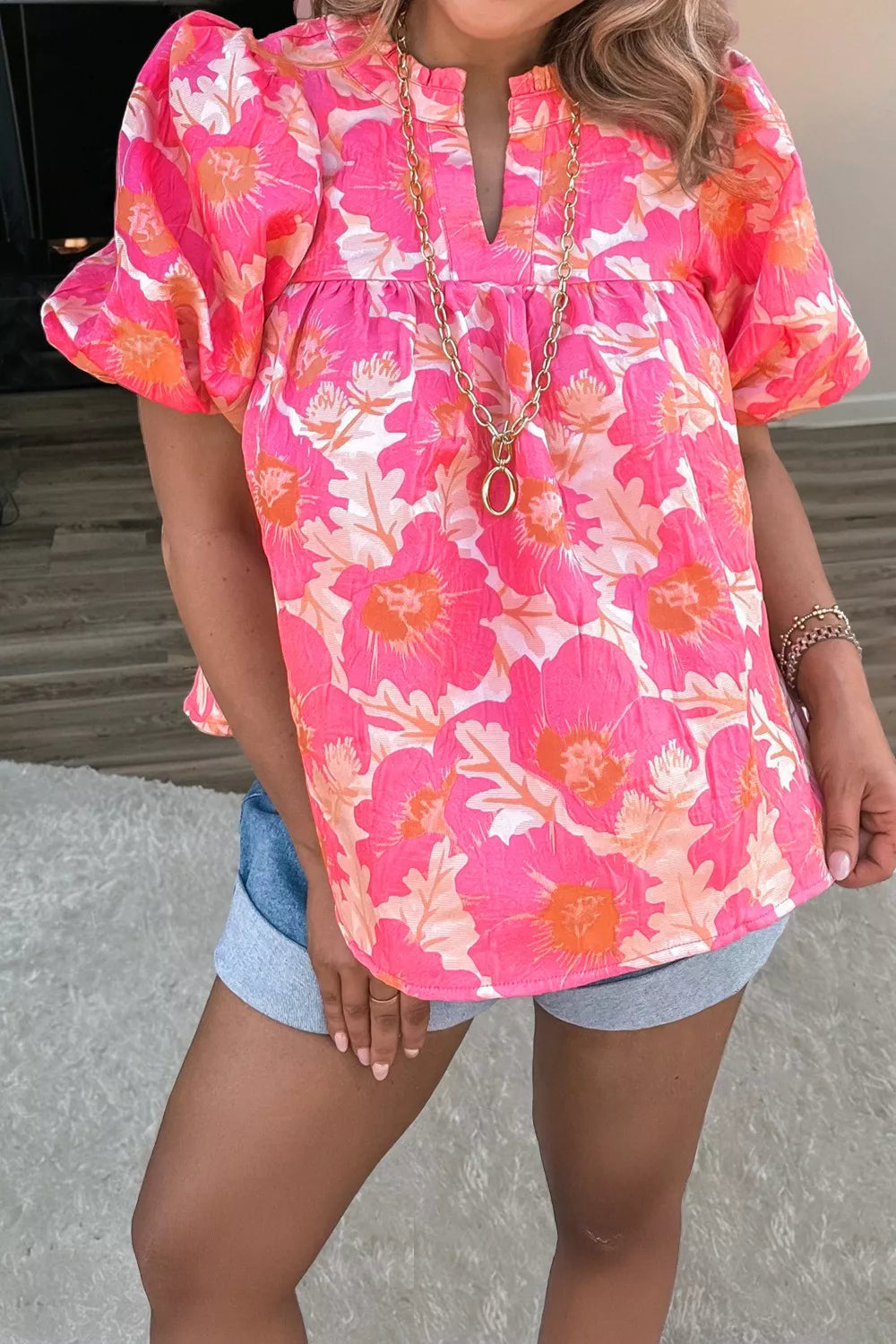Vibrant floral print polyester blouse with bubble sleeves and ruffled neckline.