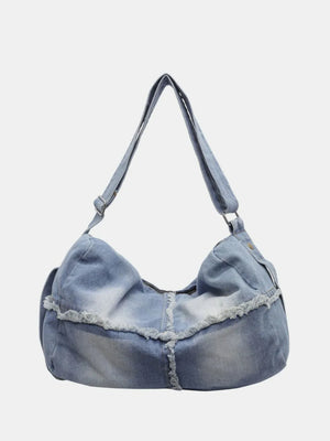 Light wash denim crossbody bag with frayed edges and slouchy silhouette.