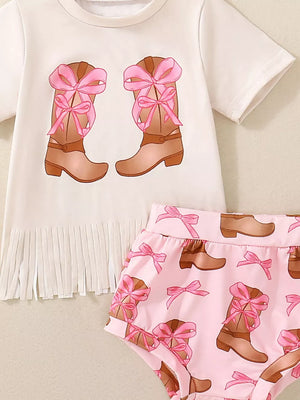 Baby set with white top featuring cowgirl boots and pink bows graphic, fringe hem, and pink bloomers with boot and bow print.