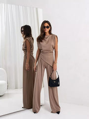 Tan satin cowl neck two-piece set with wide leg pants and asymmetrical top.