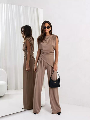 Tan satin cowl neck two-piece set with wide leg pants and asymmetrical top.