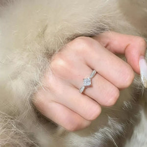 Moissanite geometric sterling silver ring with a square-cut center stone and twisted band.