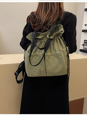 Green drawstring backpack with two front pockets and black straps.