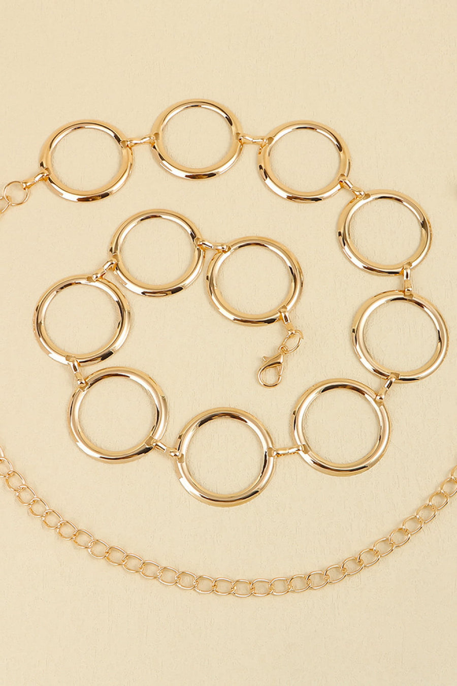 Gold geometric circle waist chain with a lobster clasp and a delicate chain accent.