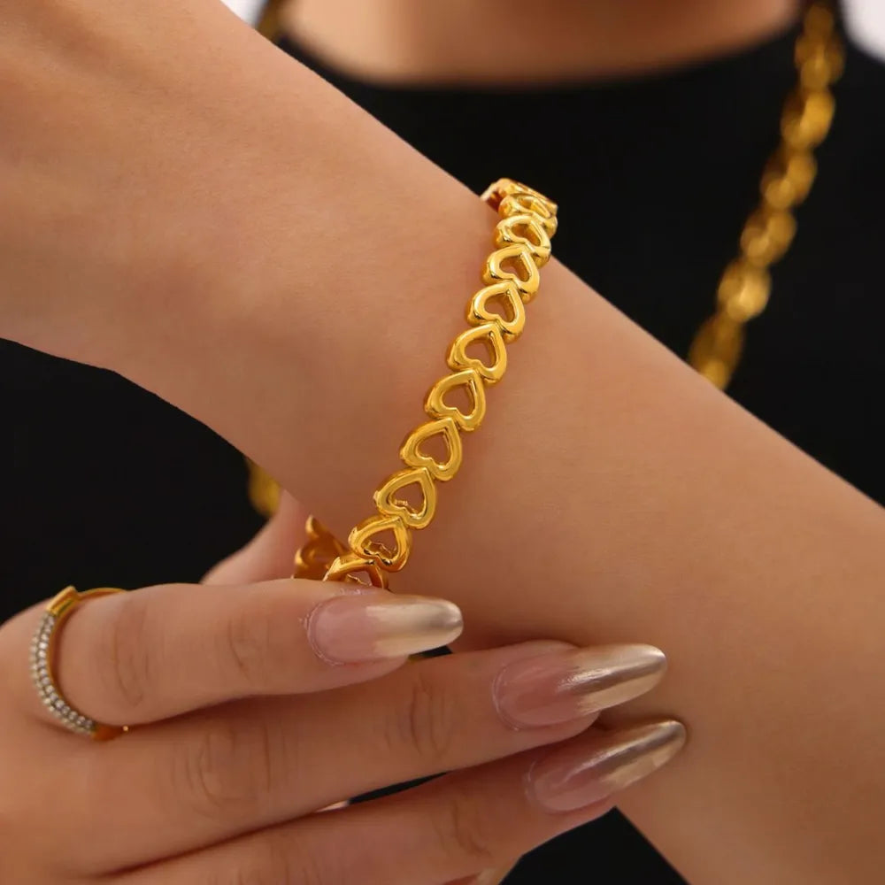 Gold heart motif chain bracelet with open heart links.