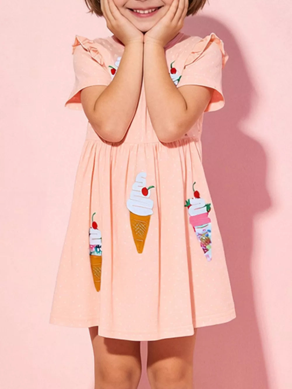 Peach cotton A-line toddler dress with ice cream cone appliques and ruffled sleeves.