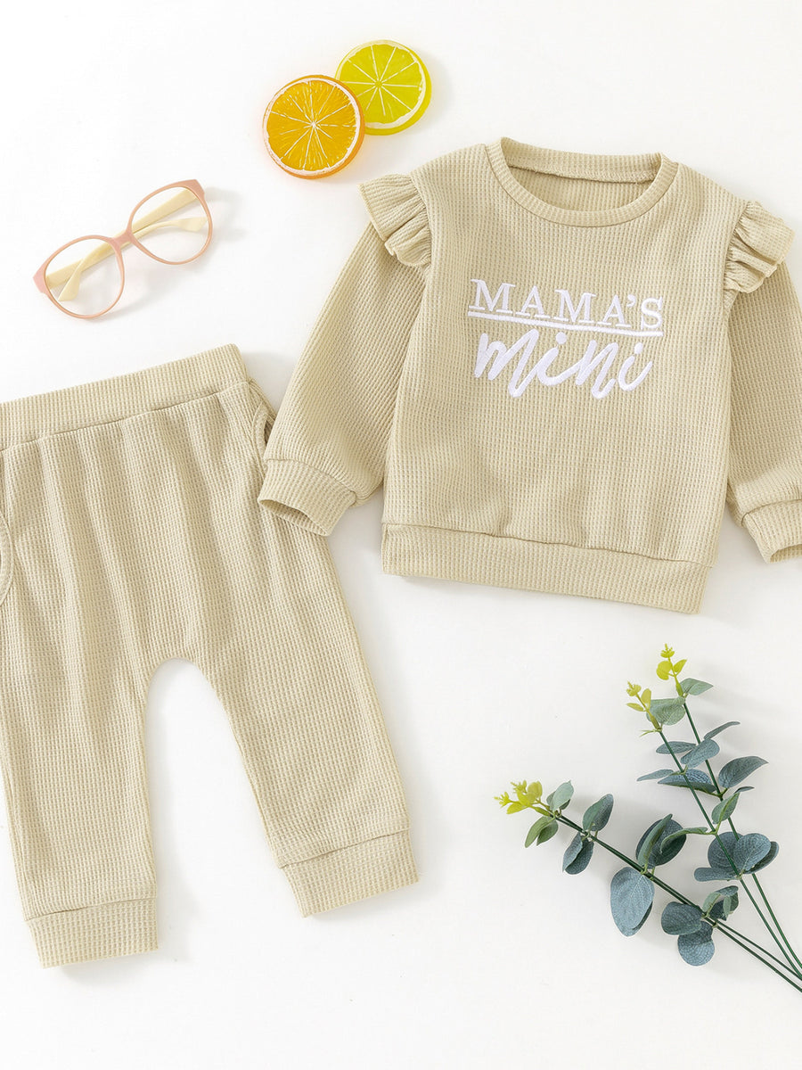 Toddler waffle knit top with ruffled sleeves and "Mama's Mini" graphic, paired with matching pants.