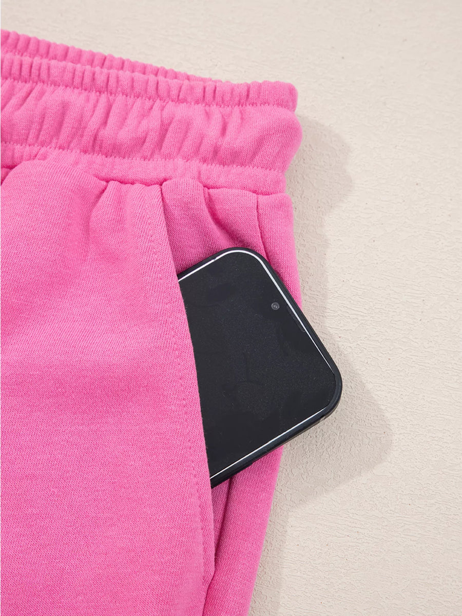 Hot pink casual pants with elastic waistband and side pocket holding a smartphone.