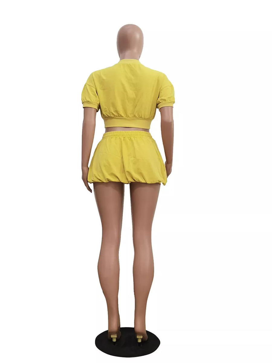 Yellow zip-up crop top and drawstring shorts set with short sleeves.