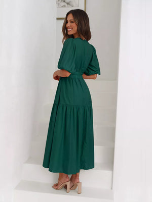 Dark green midi dress with puff sleeves, elastic waist, and tiered skirt.