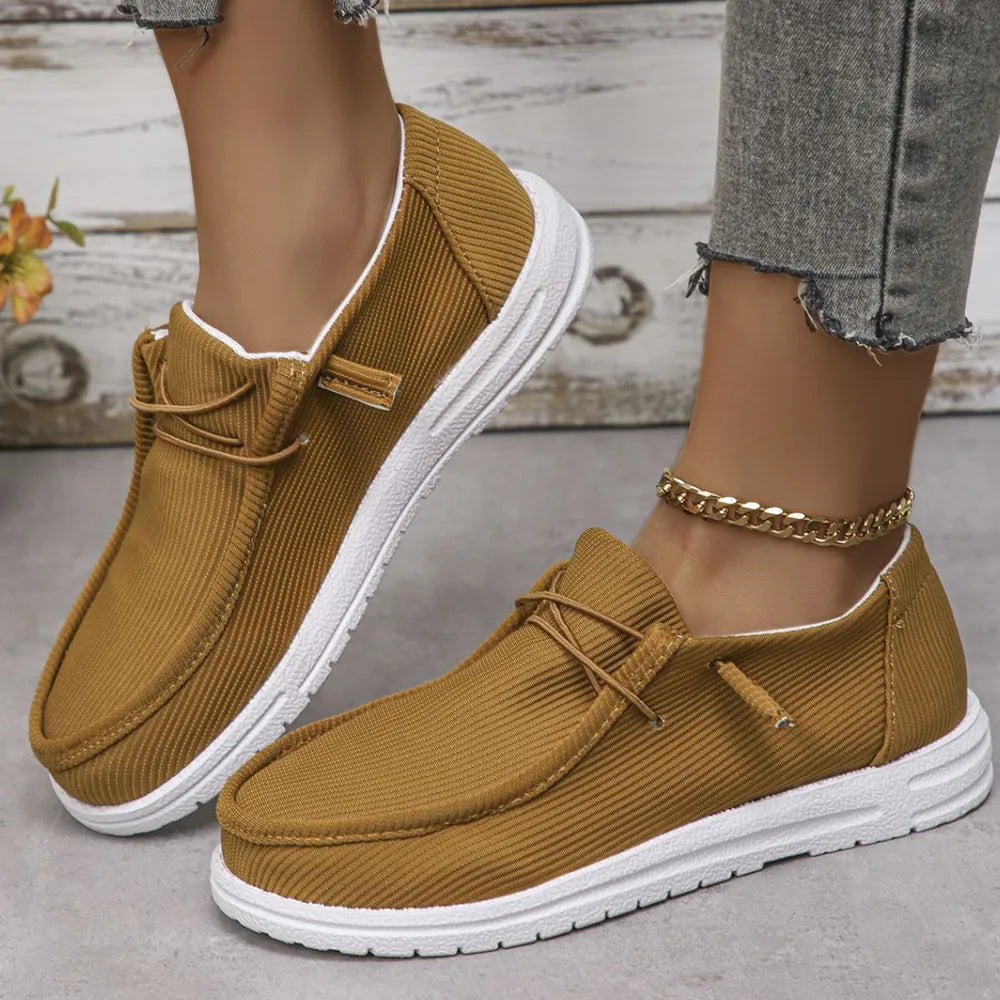 Textured slip-on espadrille sneakers in caramel with white soles and decorative laces.