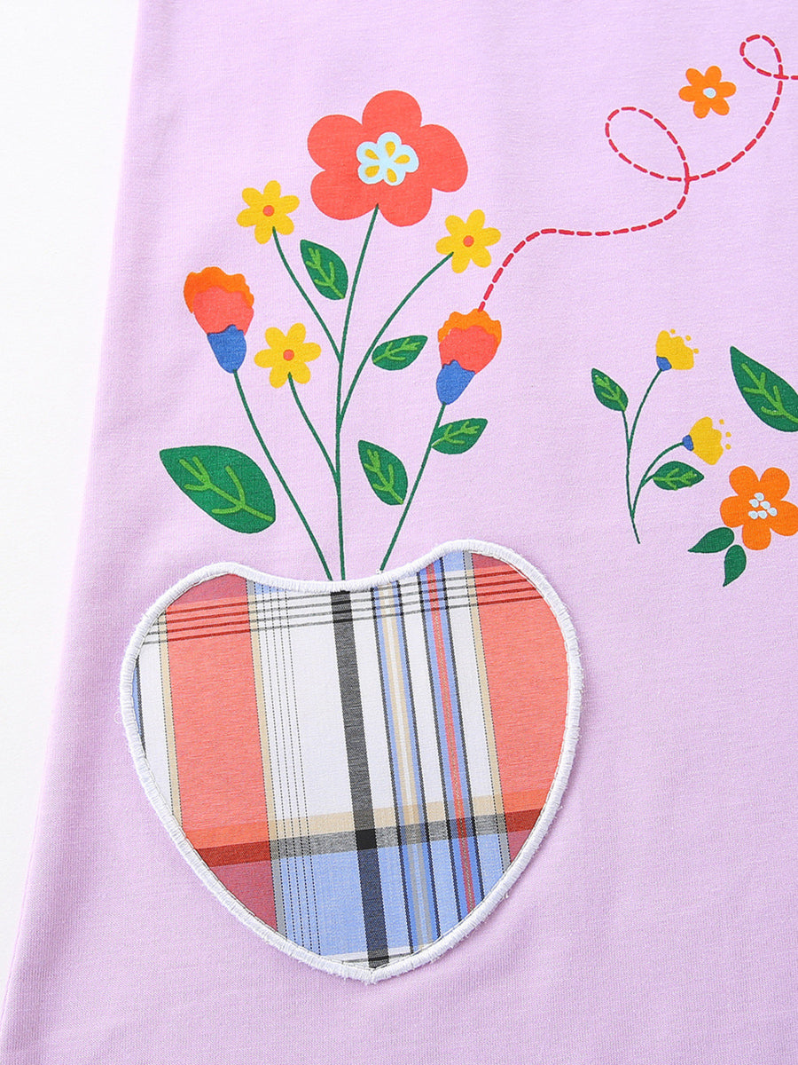 Baby dress in lilac cotton with floral print and heart-shaped plaid pocket detail.