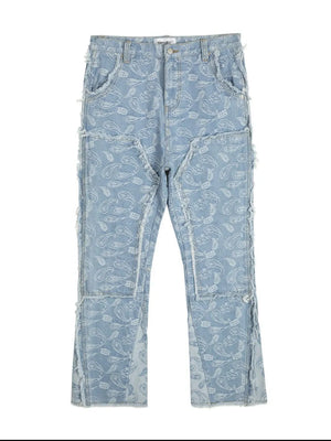 Light blue bootcut jeans with all-over paisley print and distressed panel details.