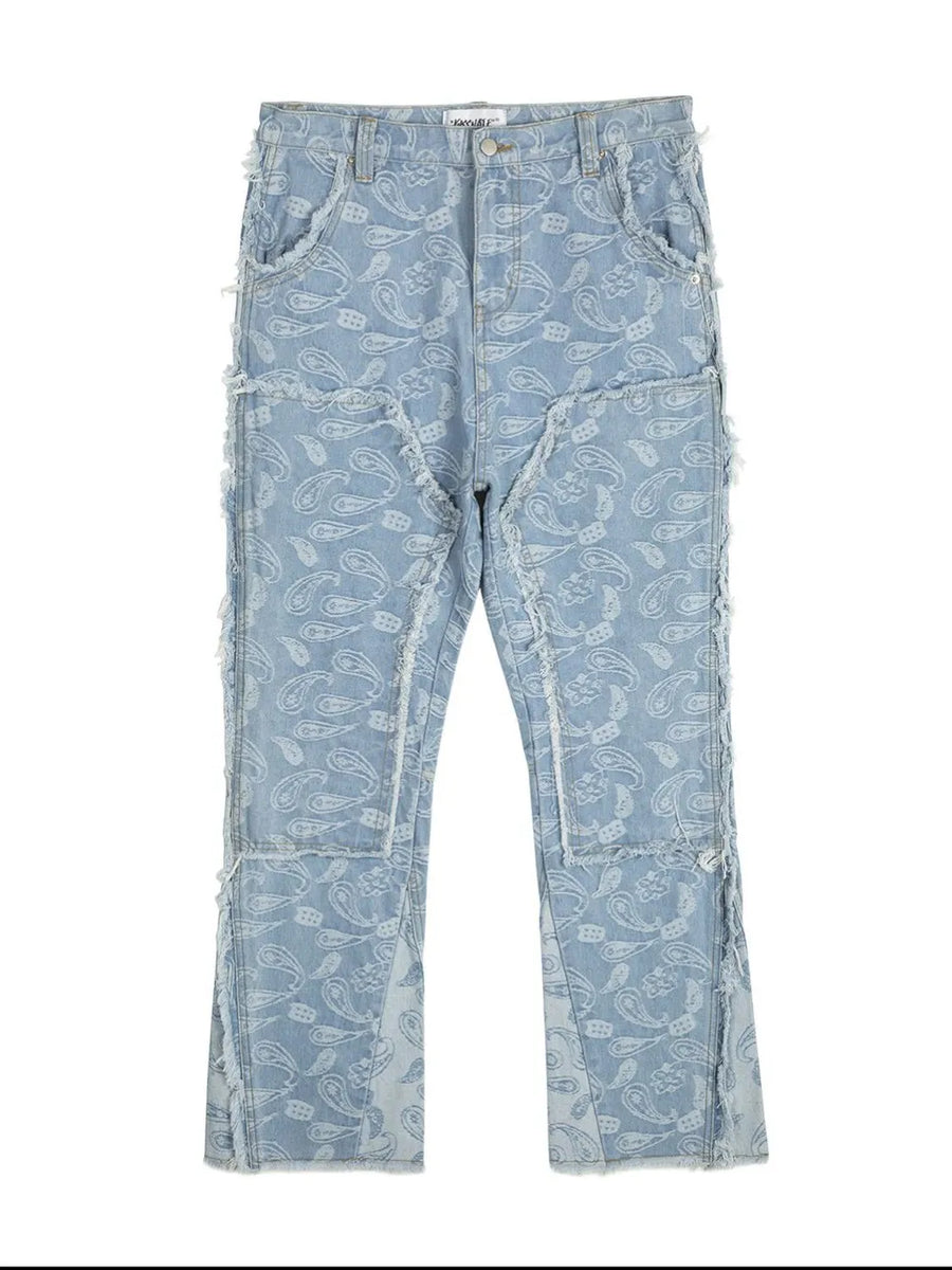 Light blue bootcut jeans with all-over paisley print and distressed panel details.