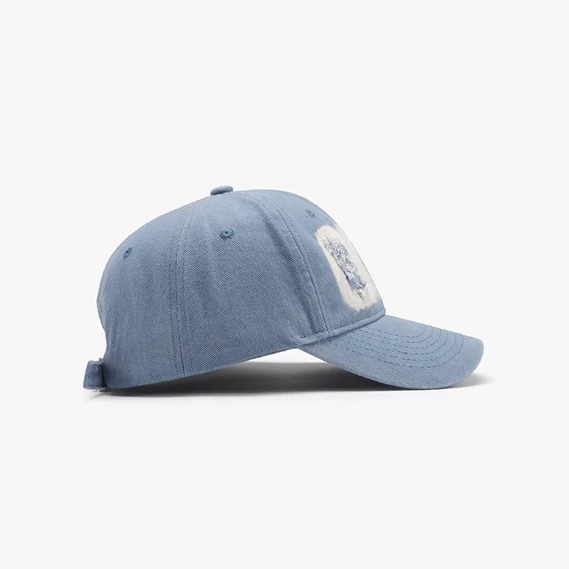 Light distressed denim baseball cap with a patch detail.