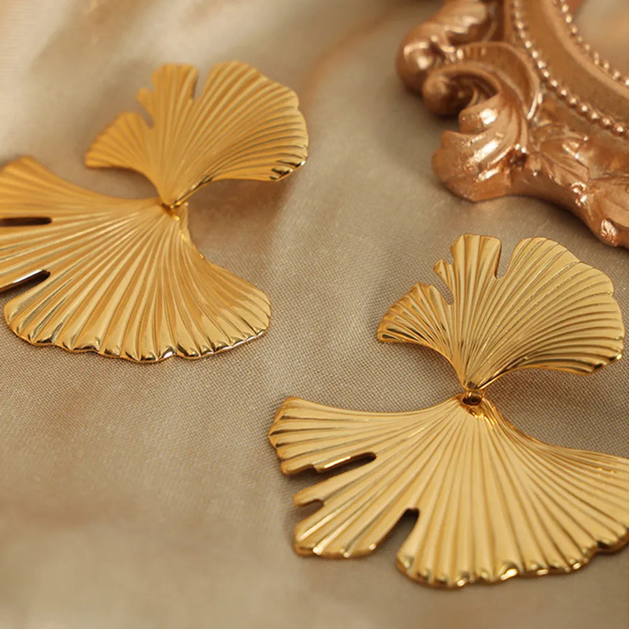 Gold Ginkgo leaf statement earrings with ribbed texture and elegant design.