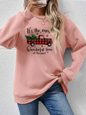Blush pink sweatshirt with a graphic of a red buffalo plaid truck carrying Christmas trees and text.