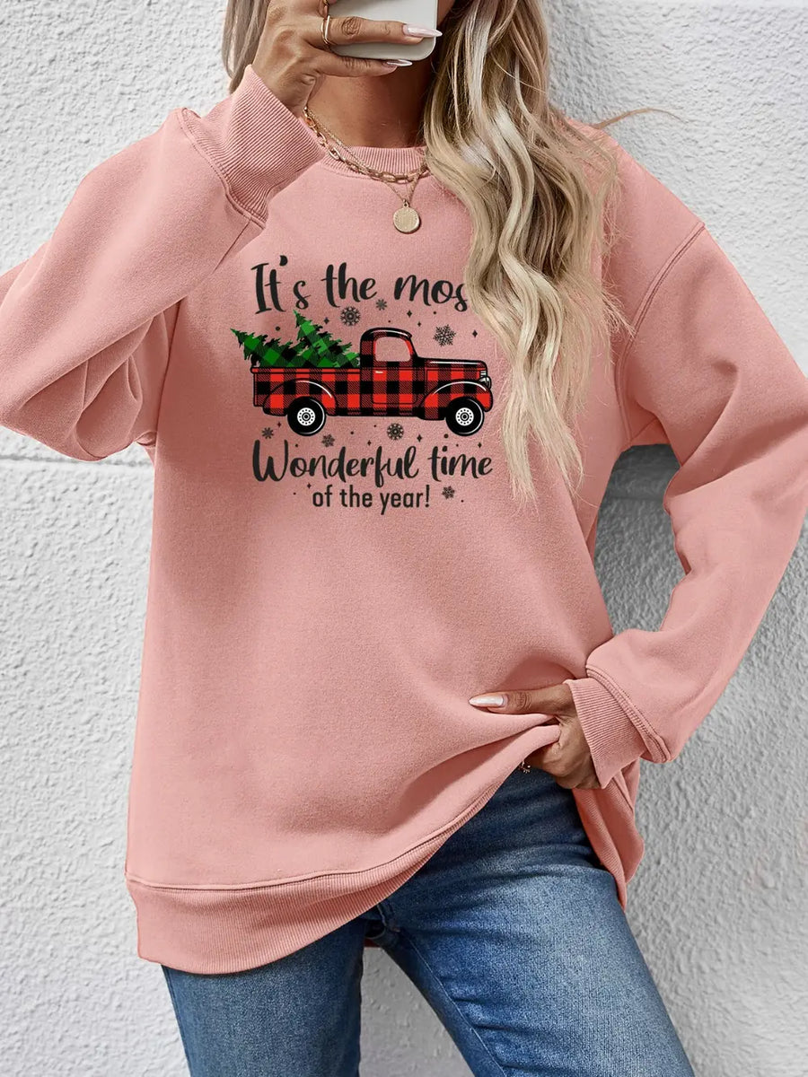 Blush pink sweatshirt with a graphic of a red buffalo plaid truck carrying Christmas trees and text.