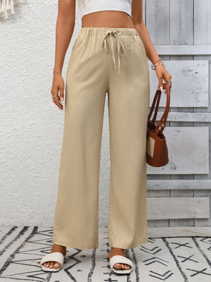 Apricot high-waist wide-leg pants with drawstring detail and relaxed fit.
