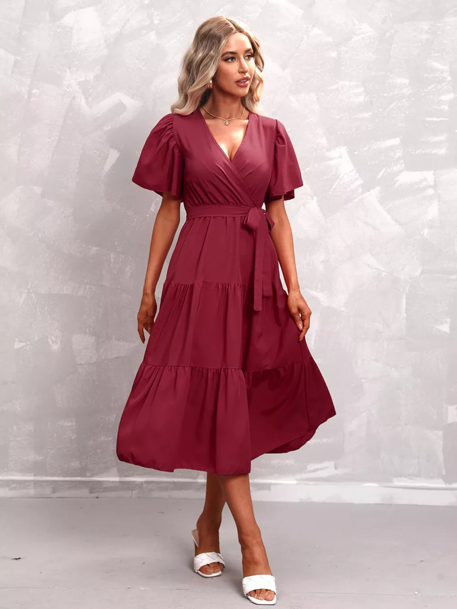 Elegant midi dress in Scarlet with flutter sleeves, V-neck, tiered skirt, and belted waist.