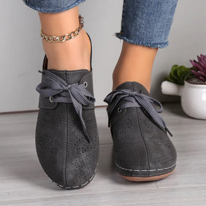 Dark Gray perforated lace-up mule flats with decorative stitching and tie closure.