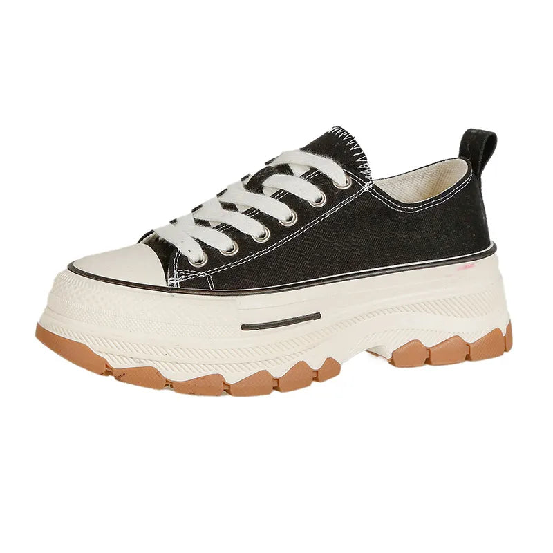 Black canvas tread sneakers with white laces and a thick platform sole.
