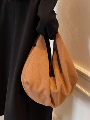 Spacious yellow brown suede shoulder bag with a visible zipper pocket detail.