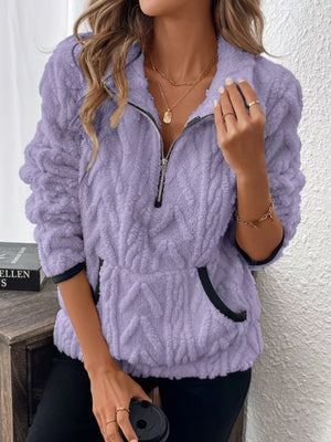 Purple sherpa half zip sweatshirt with chevron texture and black trim pockets.