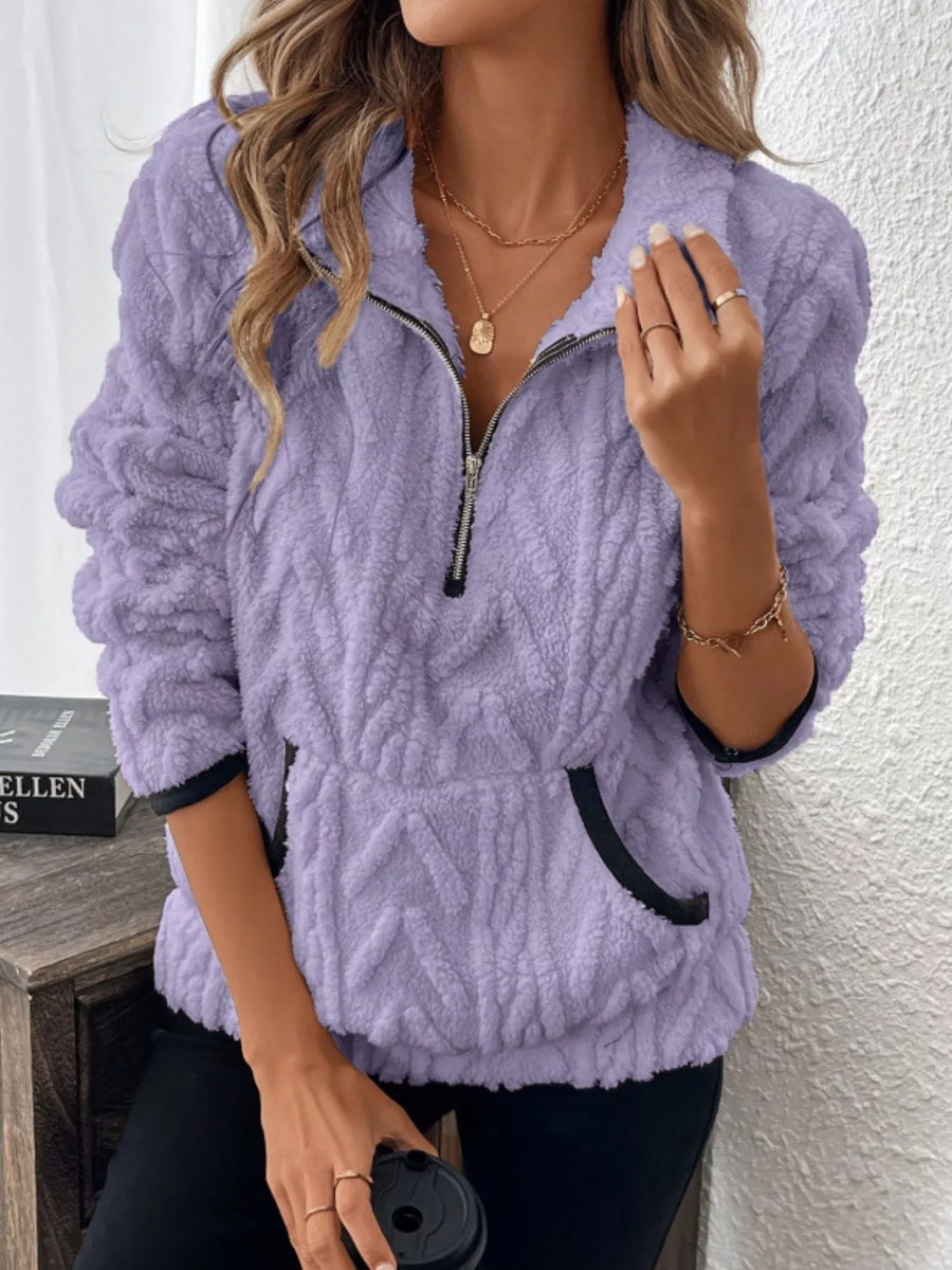 Purple sherpa half zip sweatshirt with chevron texture and black trim pockets.