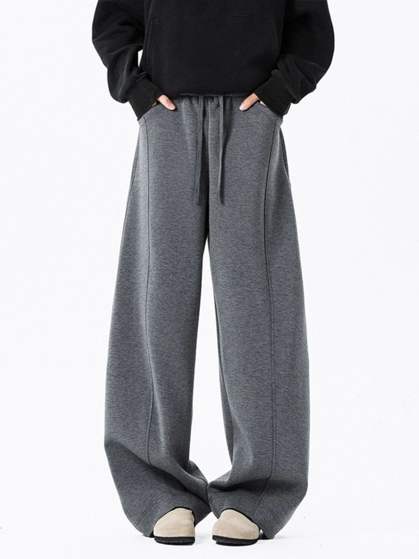 Men's dark gray drawstring wide leg sweatpants with pockets and stitched seams.