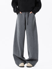 Men's dark gray drawstring wide leg sweatpants with pockets and stitched seams.