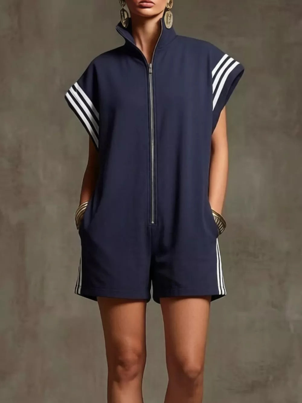 Navy blue zip-up romper with white stripes on sleeves and sides, pockets.