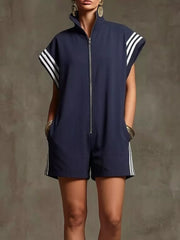 Navy blue zip-up romper with white stripes on sleeves and sides, pockets.
