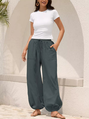 Grey relaxed harem pants with drawstring and contrast stitching detail.