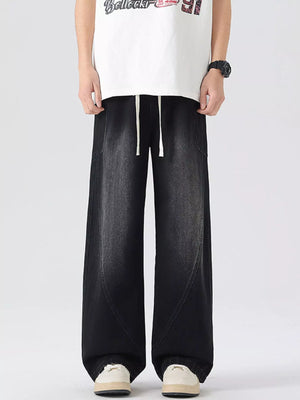 Oversized wide-leg jeans in black denim with drawstring waist and vintage wash.