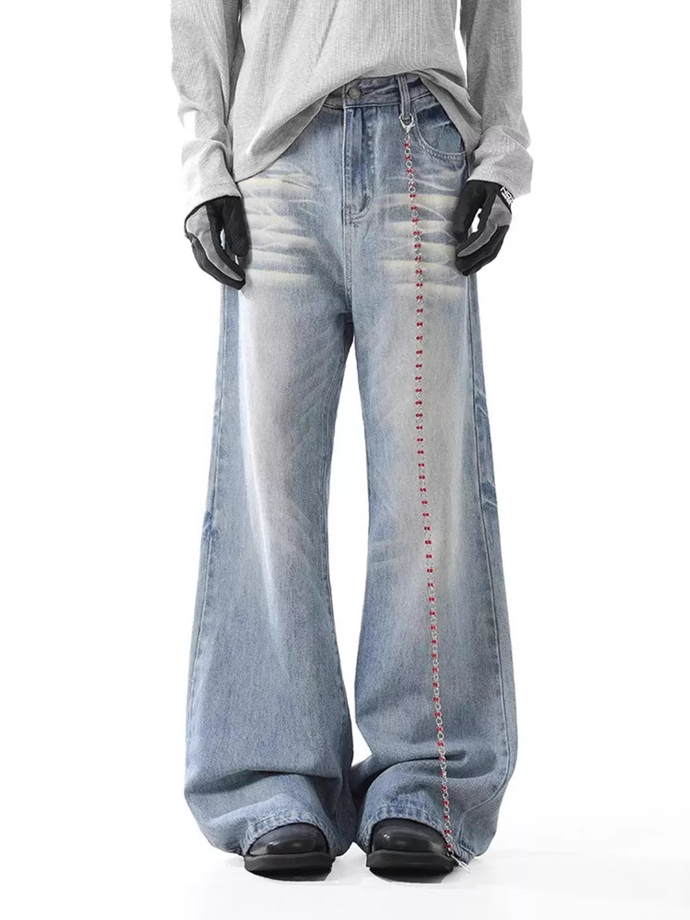 Men's light wash wide-leg jeans with button closure and decorative chain detail.